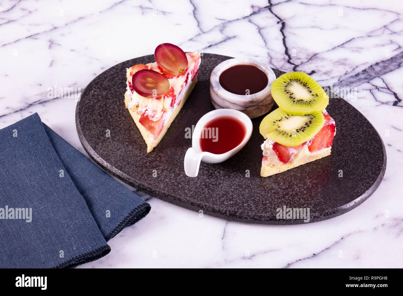 Stück Kuchen auf schwarze Platte mit Erdbeeren Stockfoto