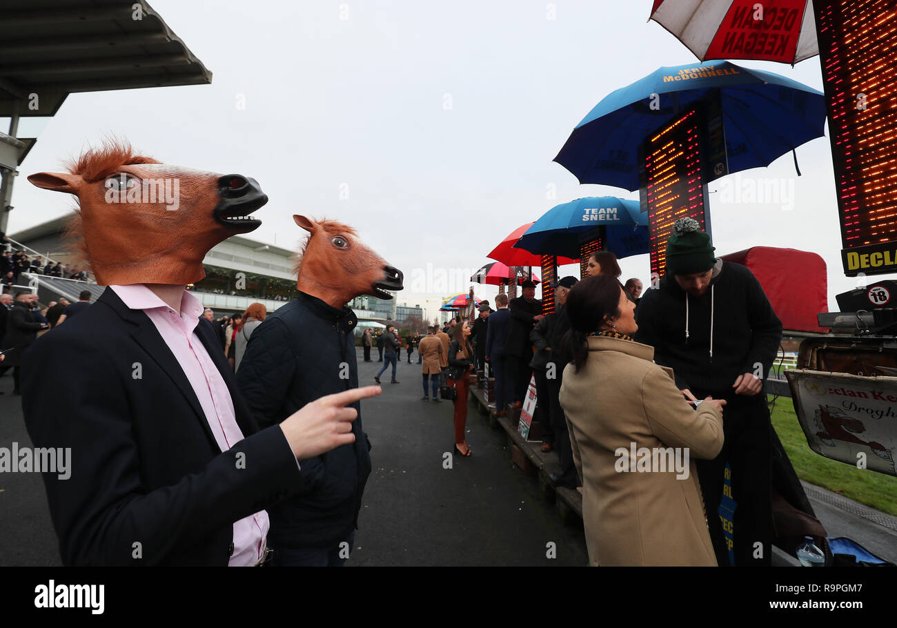 Racegoers in Fancy Dress Blick auf die Buchmacher Quoten Boards in Tag zwei des Leopardstown Weihnachten Festival an der Rennbahn Leopardstown. Stockfoto