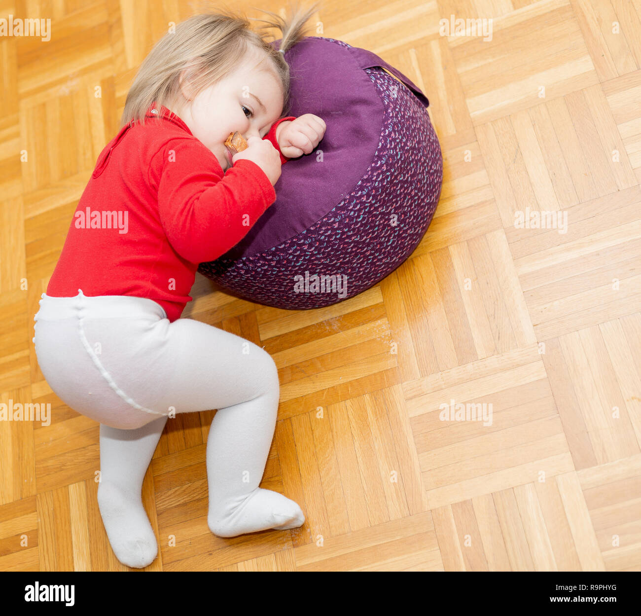 Süße Baby Mädchen essen ein Stück Brot auf dem Boden Stockfotografie - Alamy