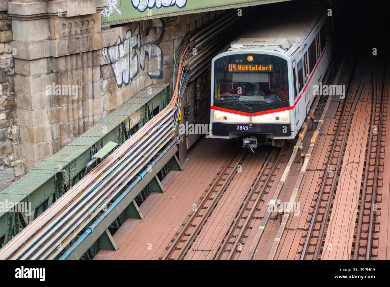 U-Bahn kommt aus einem Tunnel und geht unter Zollamtssteg Brücke während der River Crossing in Wien, Österreich. Stockfoto