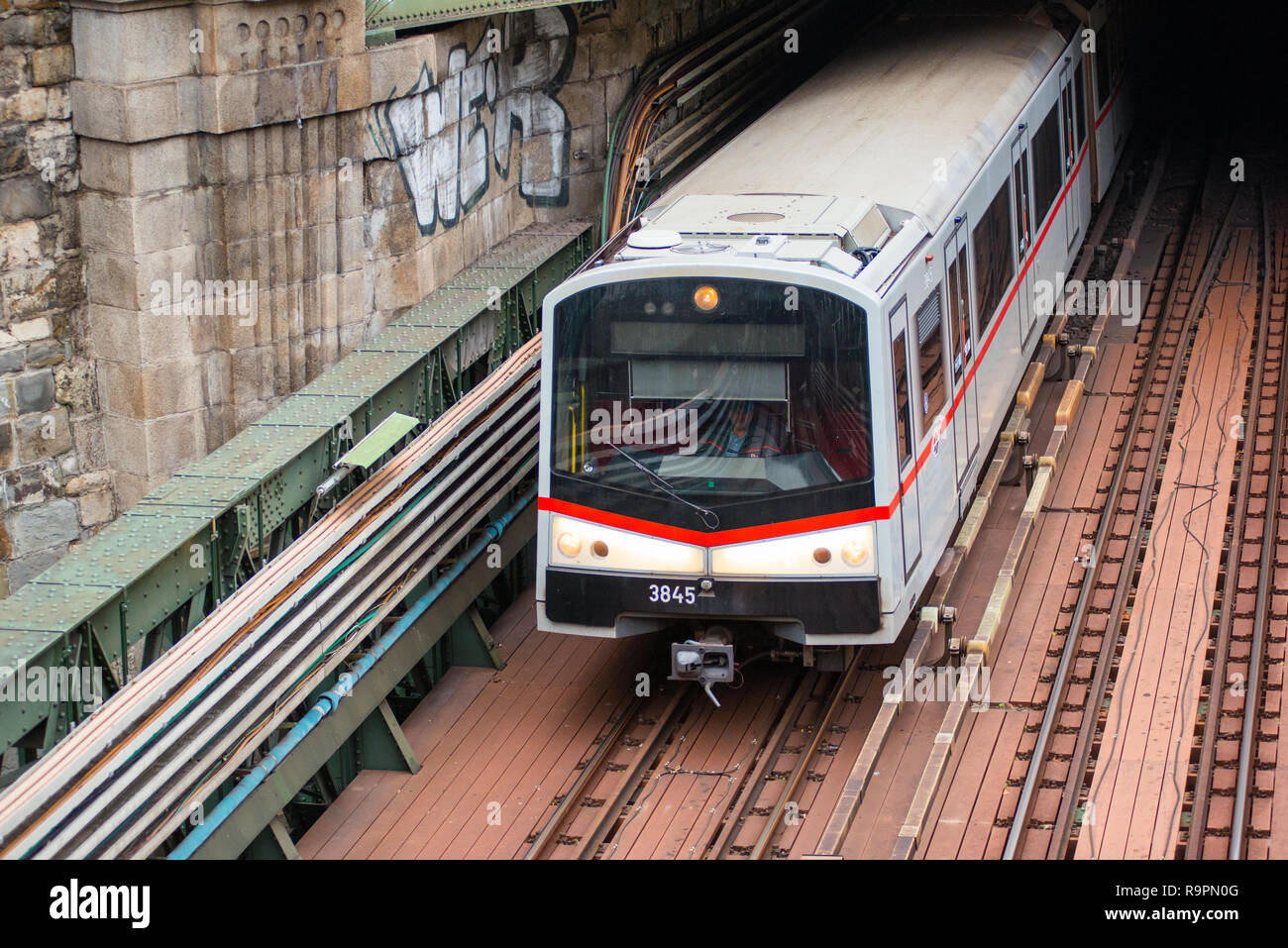 U-Bahn kommt aus einem Tunnel und geht unter Zollamtssteg Brücke während der River Crossing in Wien, Österreich. Stockfoto