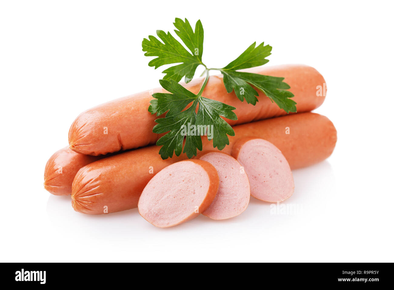 Drei rohe Würstchen und frische Petersilie auf weißem Hintergrund Stockfoto