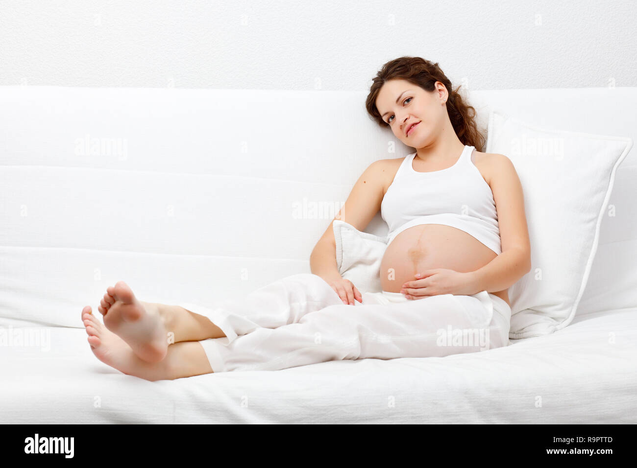 Schwangere Frau auf dem Sofa entspannen Stockfoto