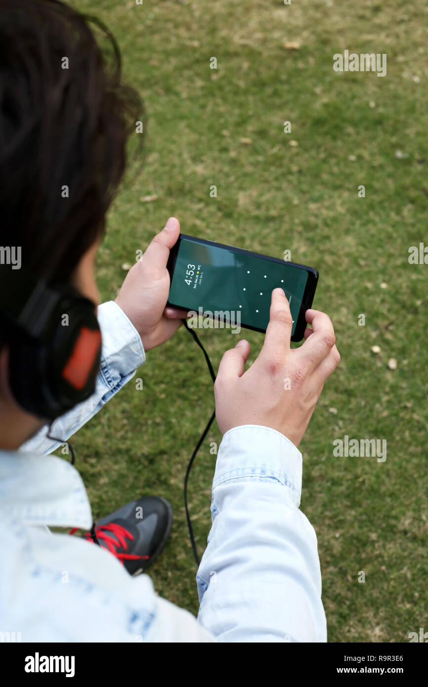 Man hört Musik mit Kopfhörer und Sie ihr Smartphone. Stockfoto