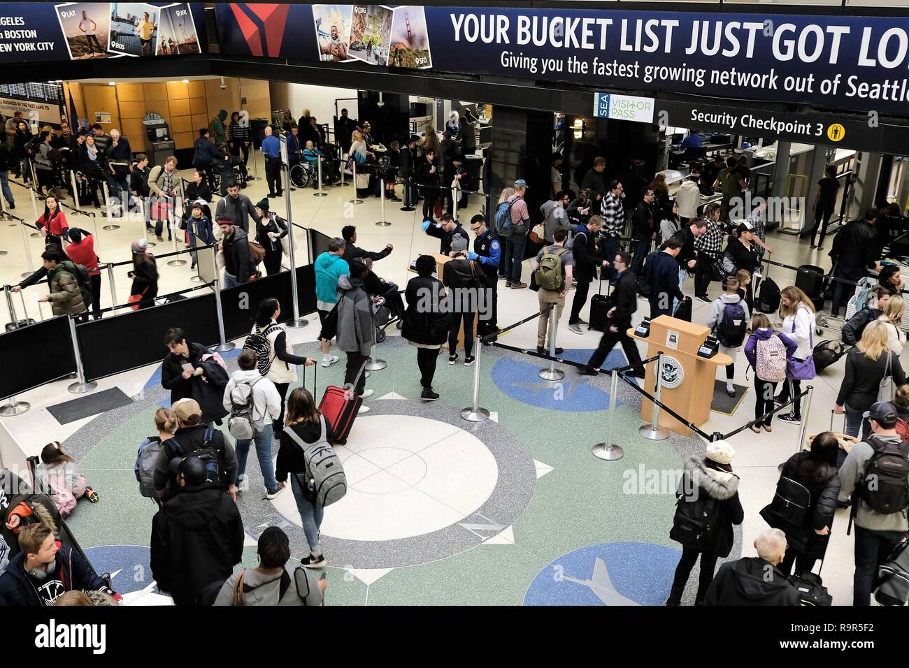 Passagiere in der Linie durch TSA Security Checkpoint bei Seattle Tacoma International Airport in Seattle, Washington, USA zu gehen. Stockfoto