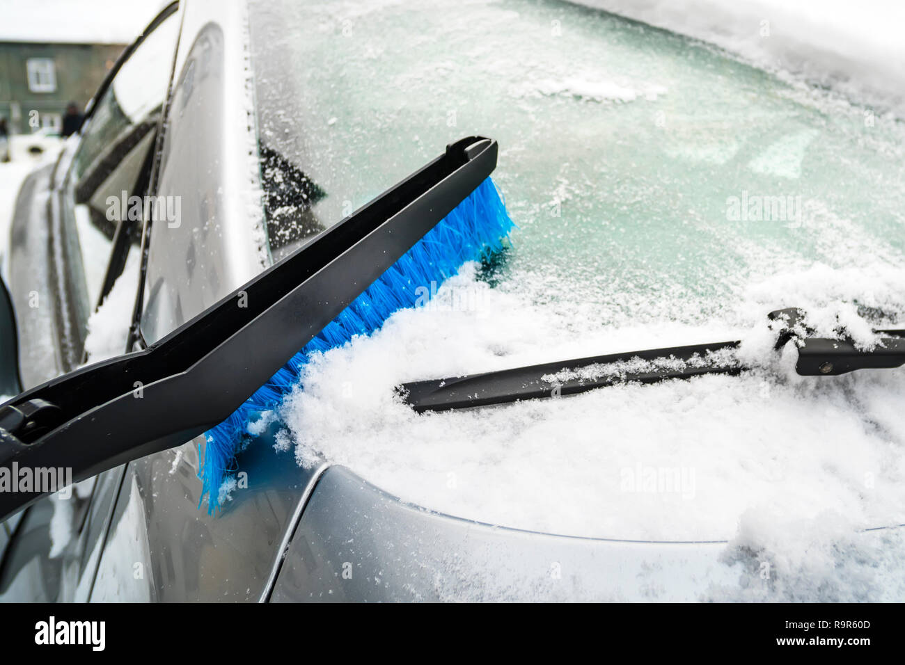 Bürste auf der Windschutzscheibe eines Autos mit Schnee. Kunststoff blau  Pinsel Reinigung Schnee. Schneeschaufeln von Automobile mit Chrom details.  Gefrorenen Fenster Glas mit Stockfotografie - Alamy