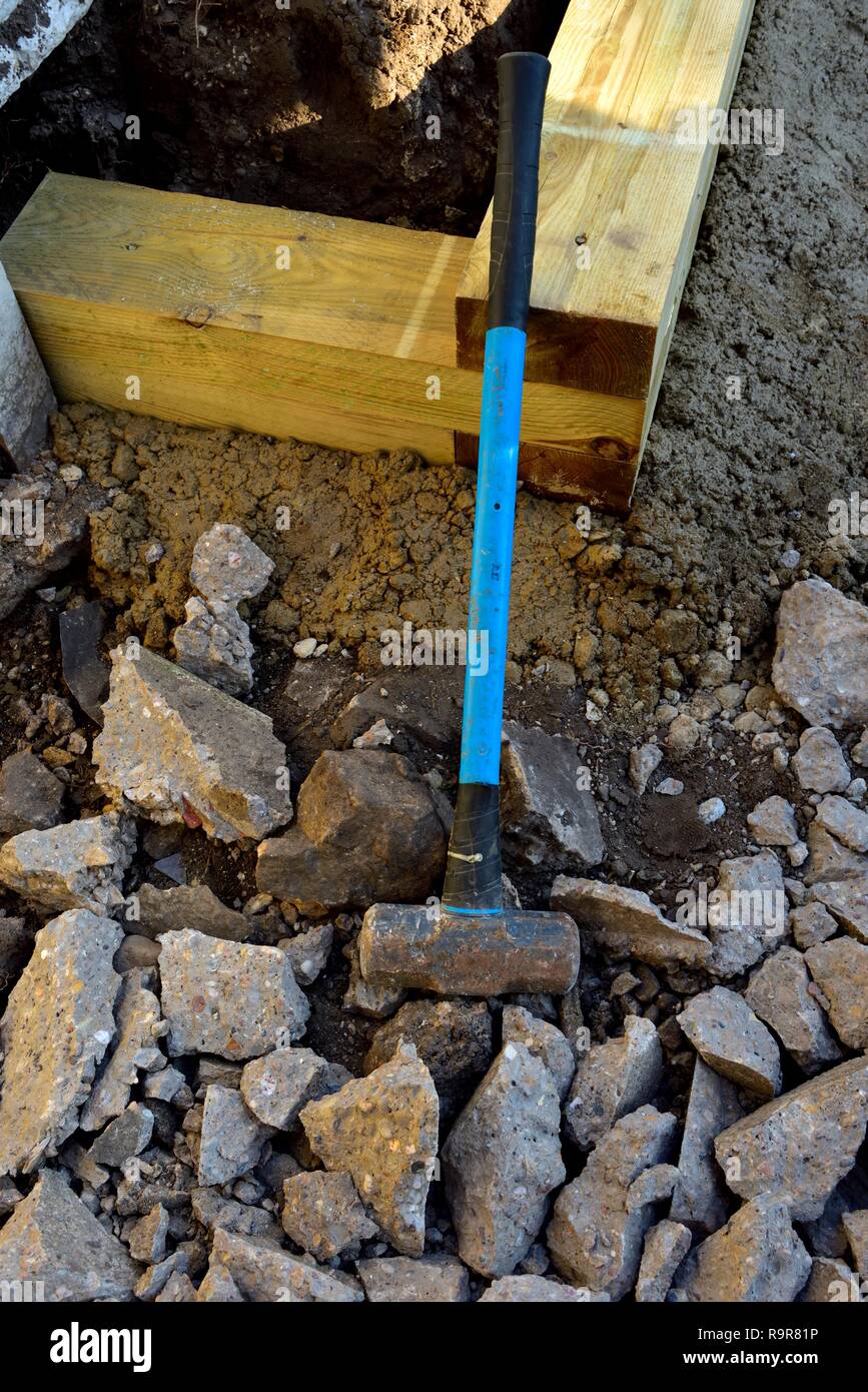 Sledge Hammer benutzt, bis Beton auf einem britischen Garten Renovierung zu brechen. Stockfoto