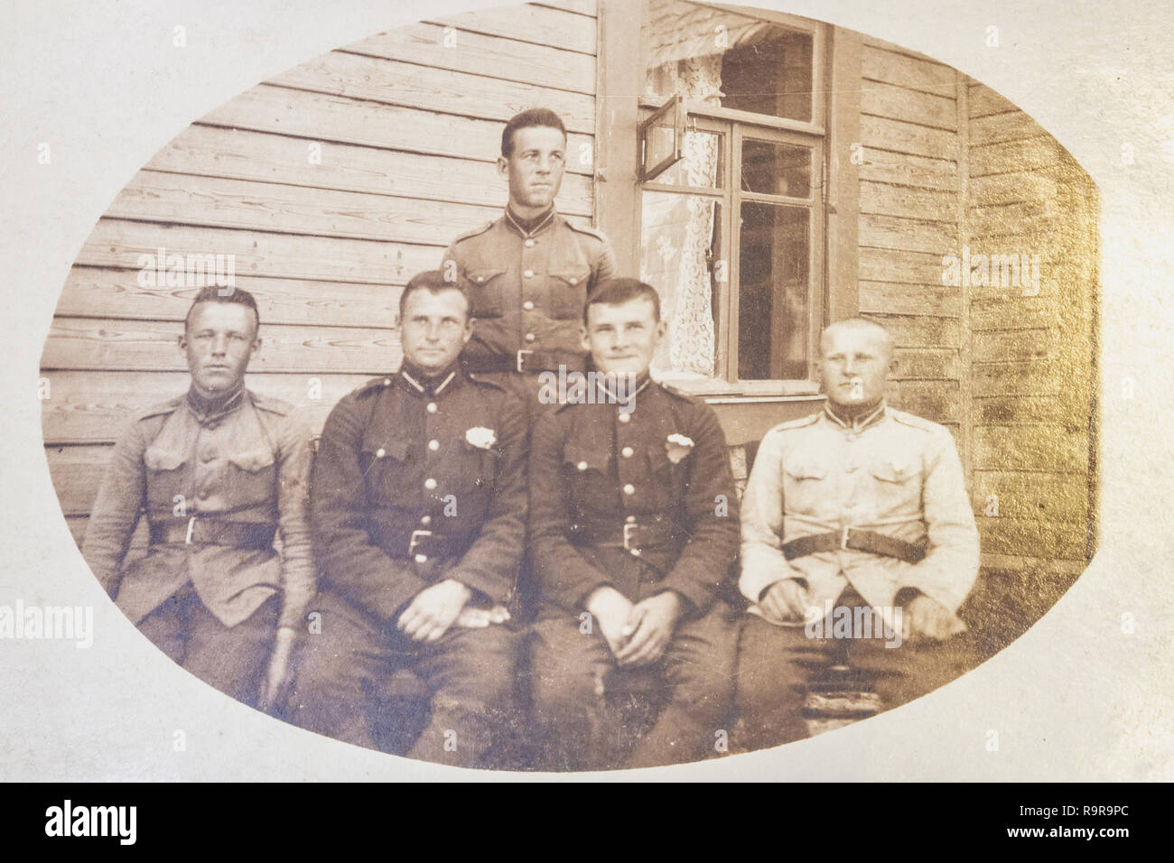 Lettland - 1930er Jahre: Eine antike Foto zeigt fünf Soldaten vor Holzhaus posing Stockfoto