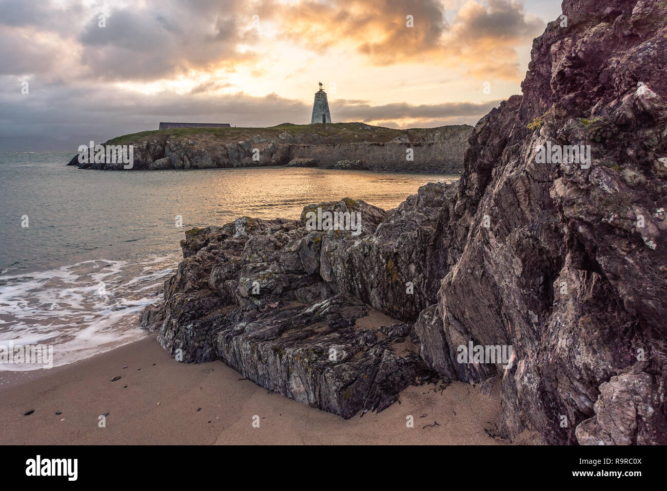 Die llanddwyn Island Lighthouse, Goleudy Twr Bach am Ynys Llanddwyn auf Anglesey, Nordwales bei Sonnenaufgang. Stockfoto