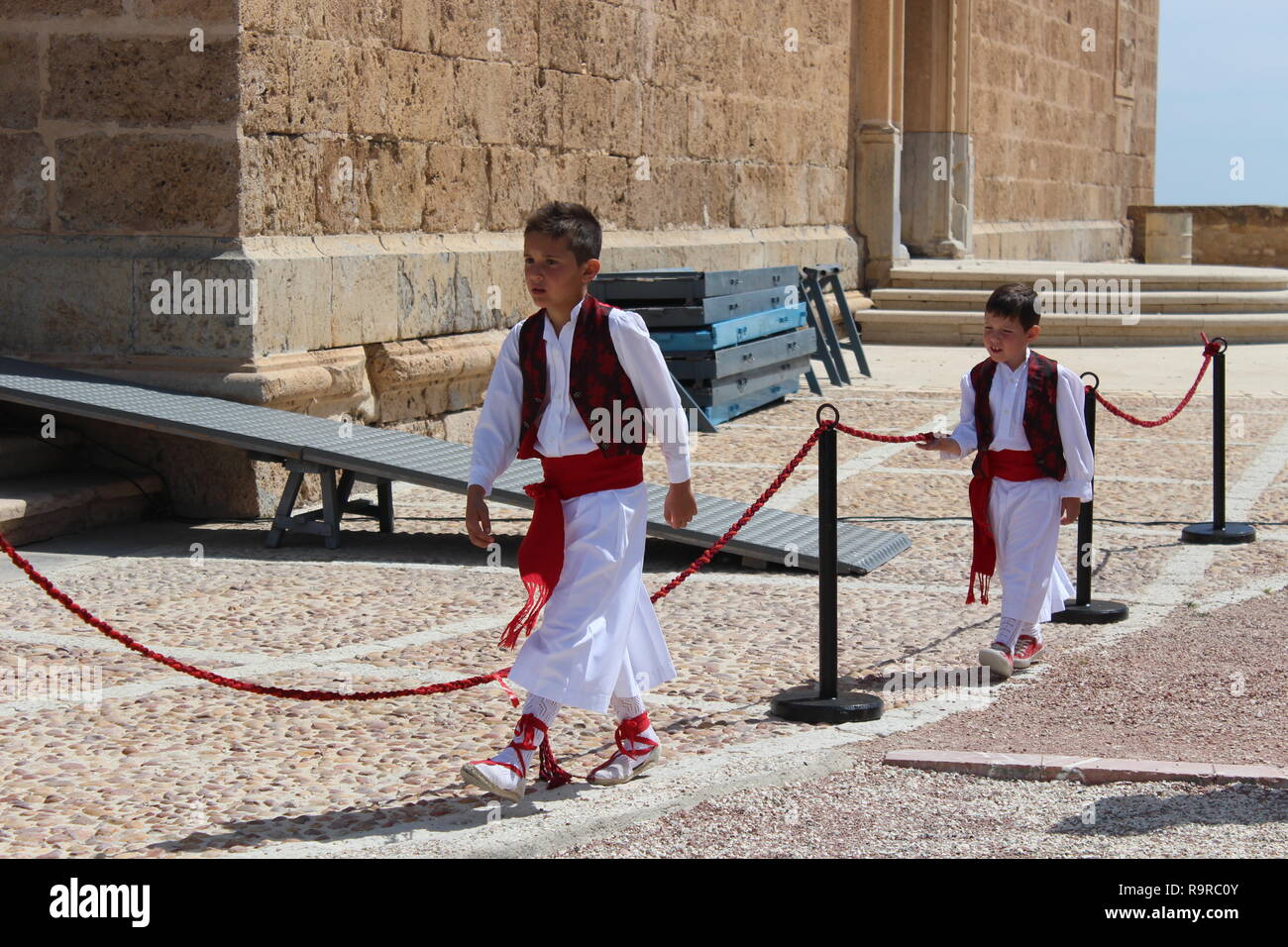 Zwei Jungen, die traditionelle Spanische rote und weiße Kostüm für den Dienst in der Basilika der Santísima, Caravaca de la Cruz, Murcia, Spanien. Stockfoto