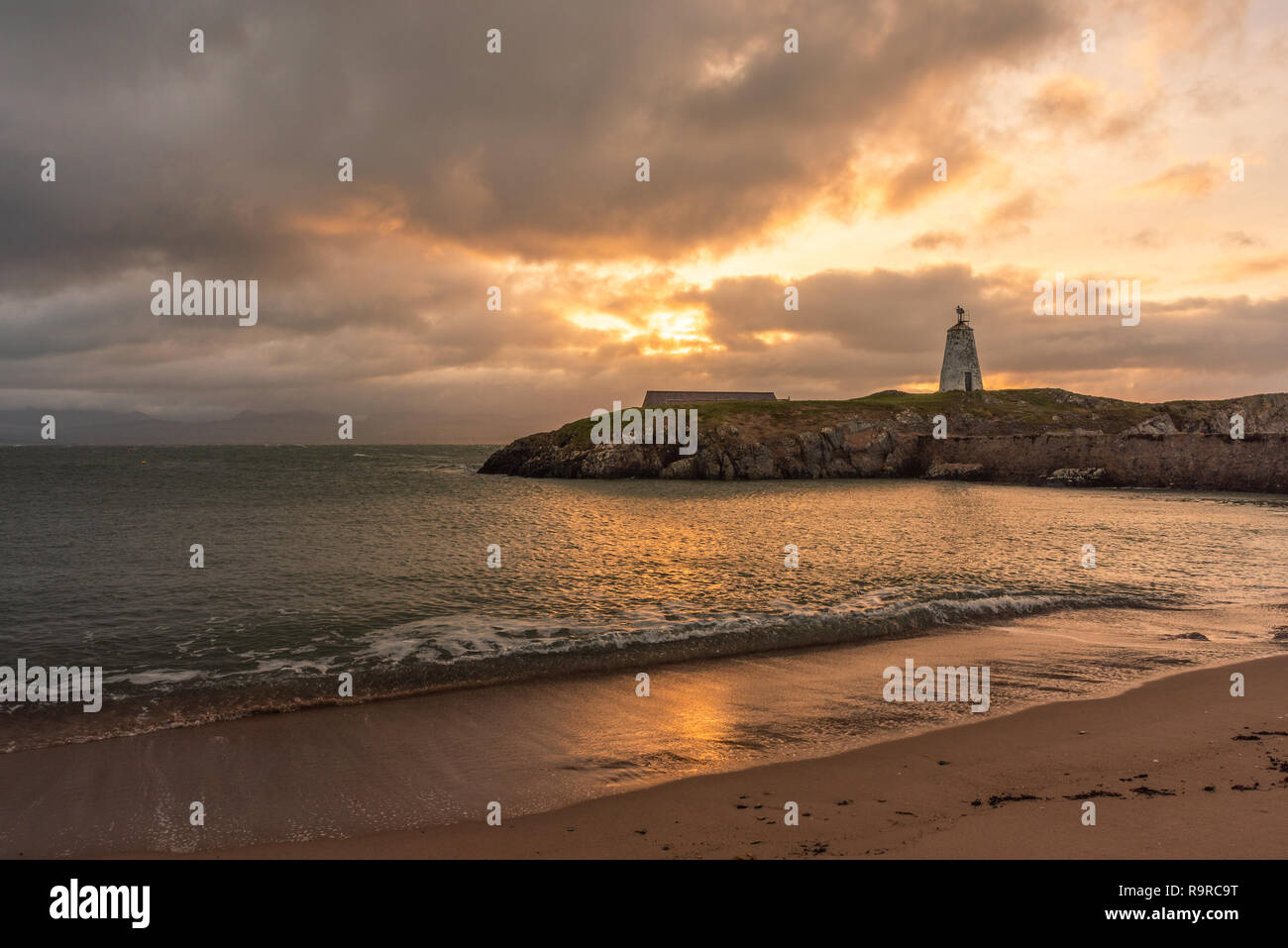 Die llanddwyn Island Lighthouse, Goleudy Twr Bach am Ynys Llanddwyn auf Anglesey, Nordwales bei Sonnenaufgang. Stockfoto