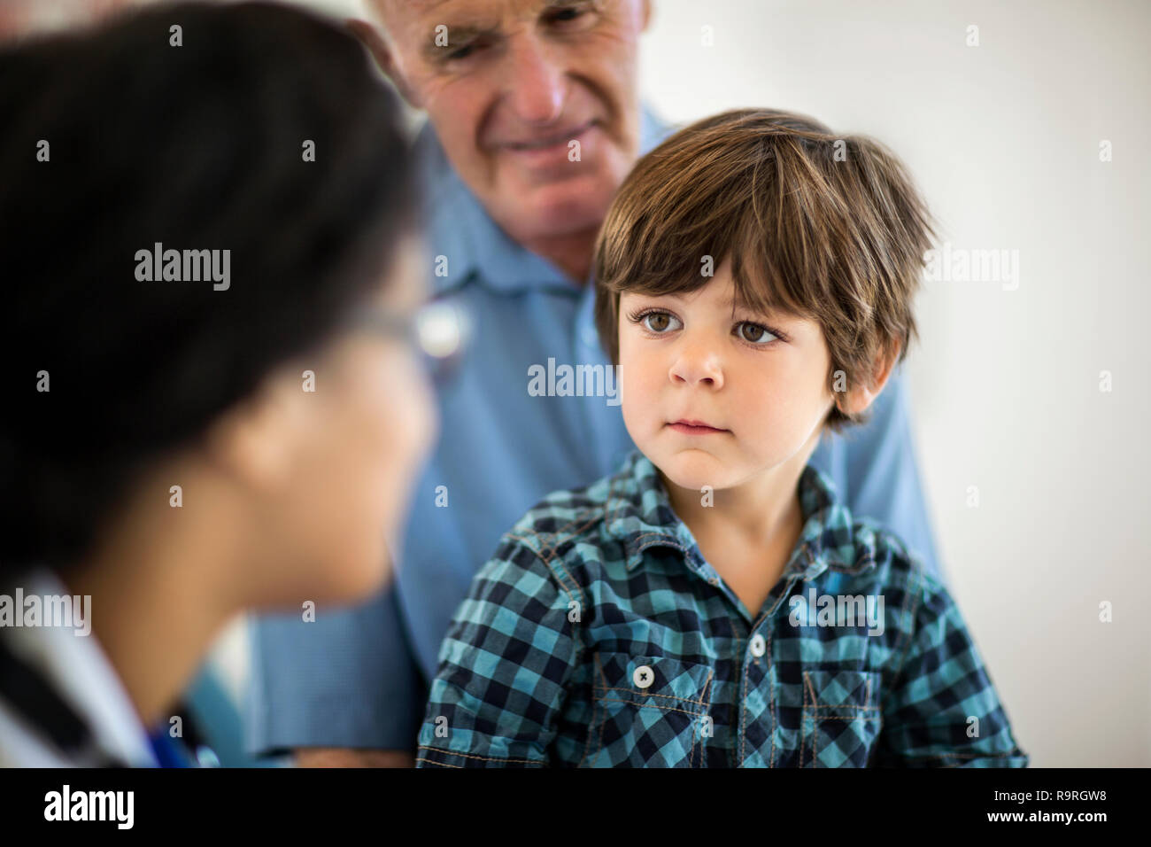 Ältere Menschen und junge Enkel genau hinzuhören, um einen Arzt Termin beim Arzt. Stockfoto