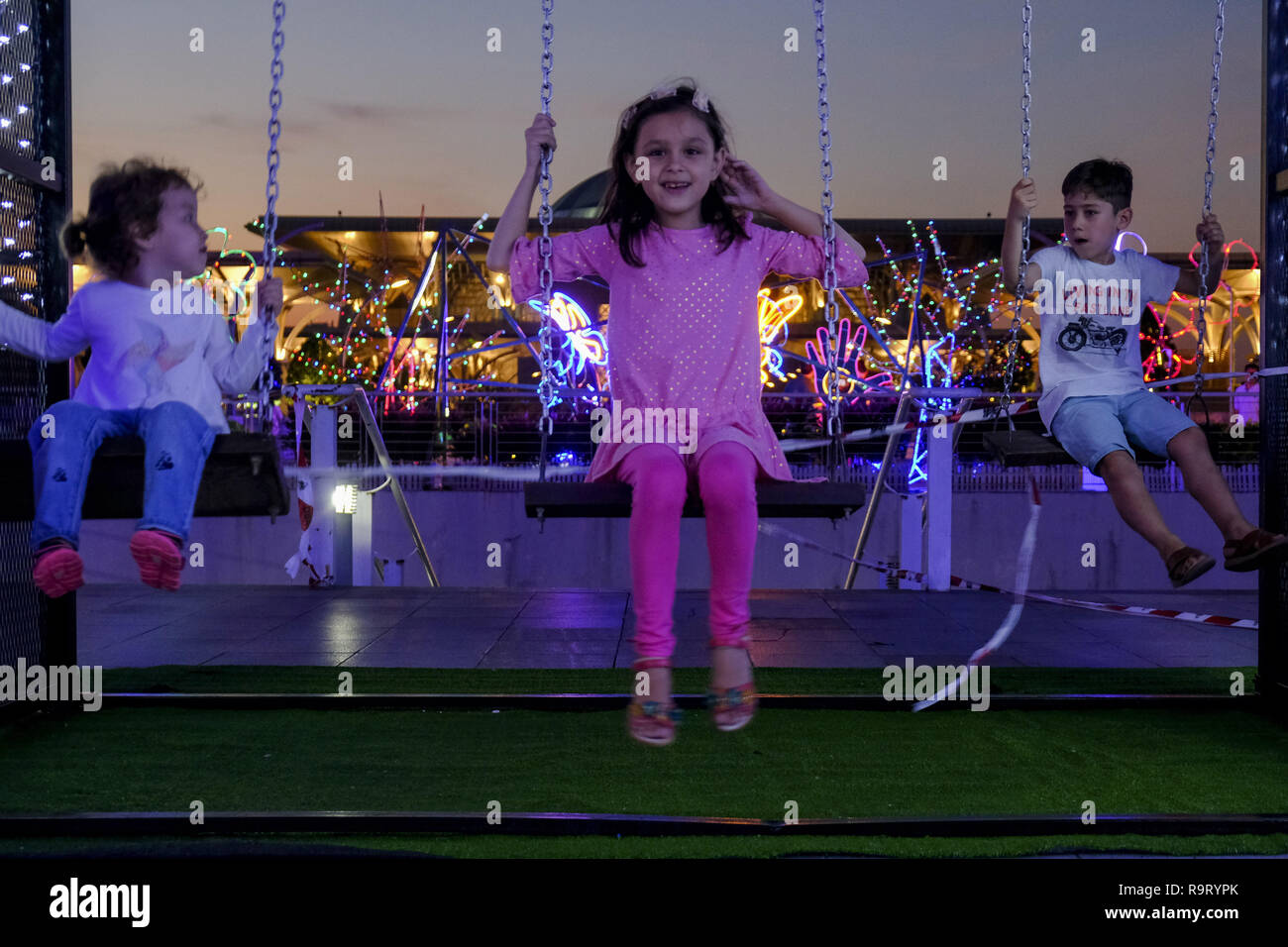 Putrajaya, Kuala Lumpur, Malaysia. 28 Dez, 2018. Süße kleine ausländische Kinder, die im Moment auf einer Schaukel an Licht und Bewegung Putrajaya (LAMPU) Festival 2018. Licht und Bewegung Putrajaya oder als LAMPU Festival bekannt ist am 28. bis 31. Dezember jeden Jahres statt und dieses Jahr LAMPU Thema 2018 ist''˜ Farben von Putrajaya" mit der Unterzeichnung des Grand Projektion. Credit: Faris Hadziq/SOPA Images/ZUMA Draht/Alamy leben Nachrichten Stockfoto