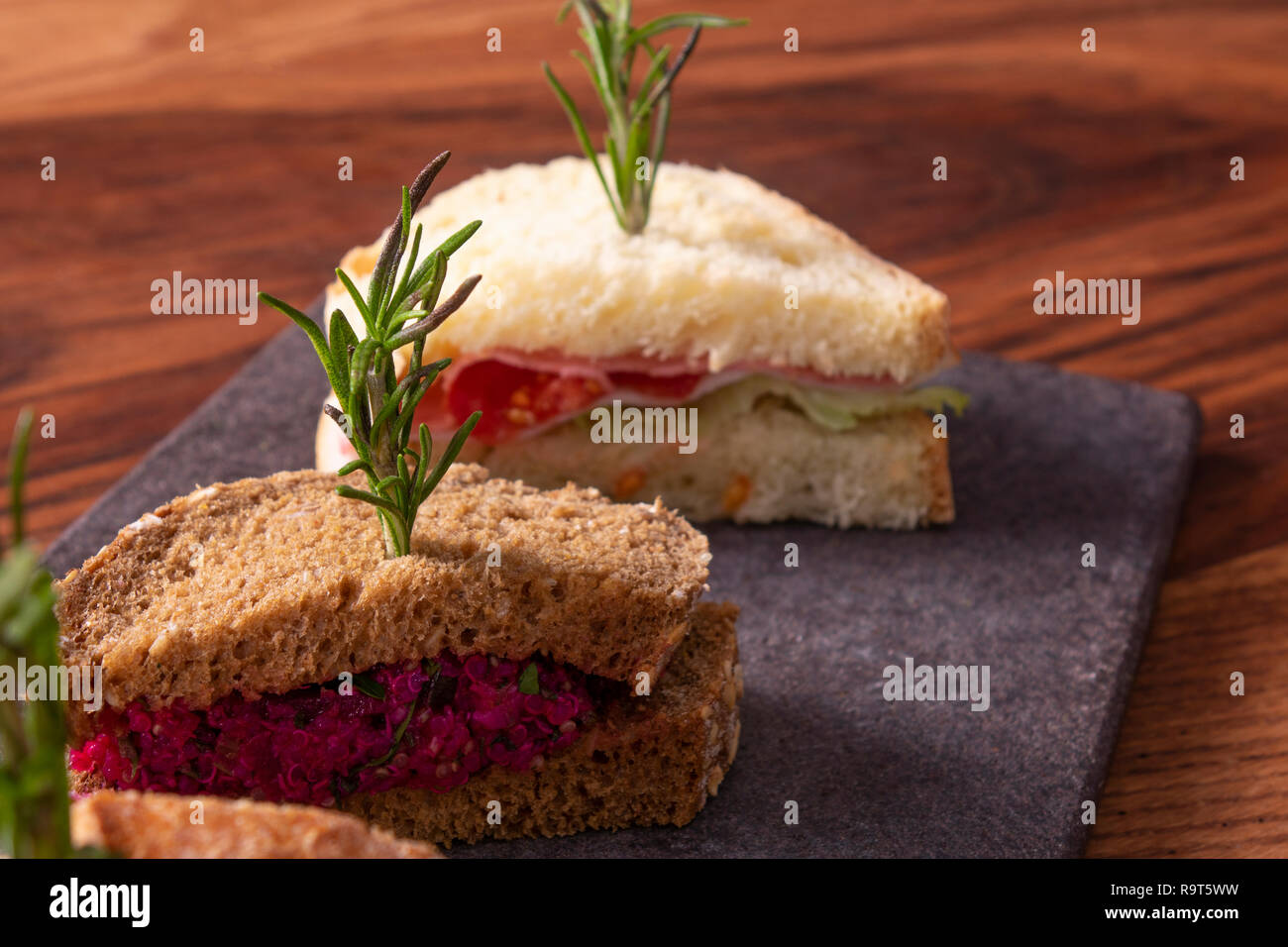 Drei Sandwiches mit Salat, Schinken, Käse und Tomaten auf Marmor tisch. Stockfoto