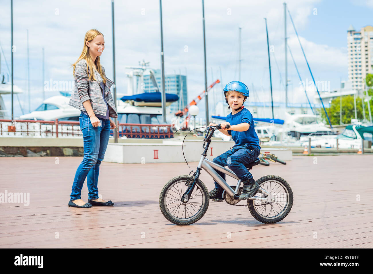 Mama lehrt Sohn ein Fahrrad im Park zu fahren Stockfoto