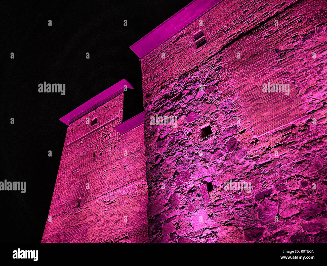 Mittelalterliche Burg außen Nacht Szene während der Festivals. Surreal anzeigen mit sehr bunten und lebhaften Ausleuchtung. Hämeenlinna, Finnland Stockfoto