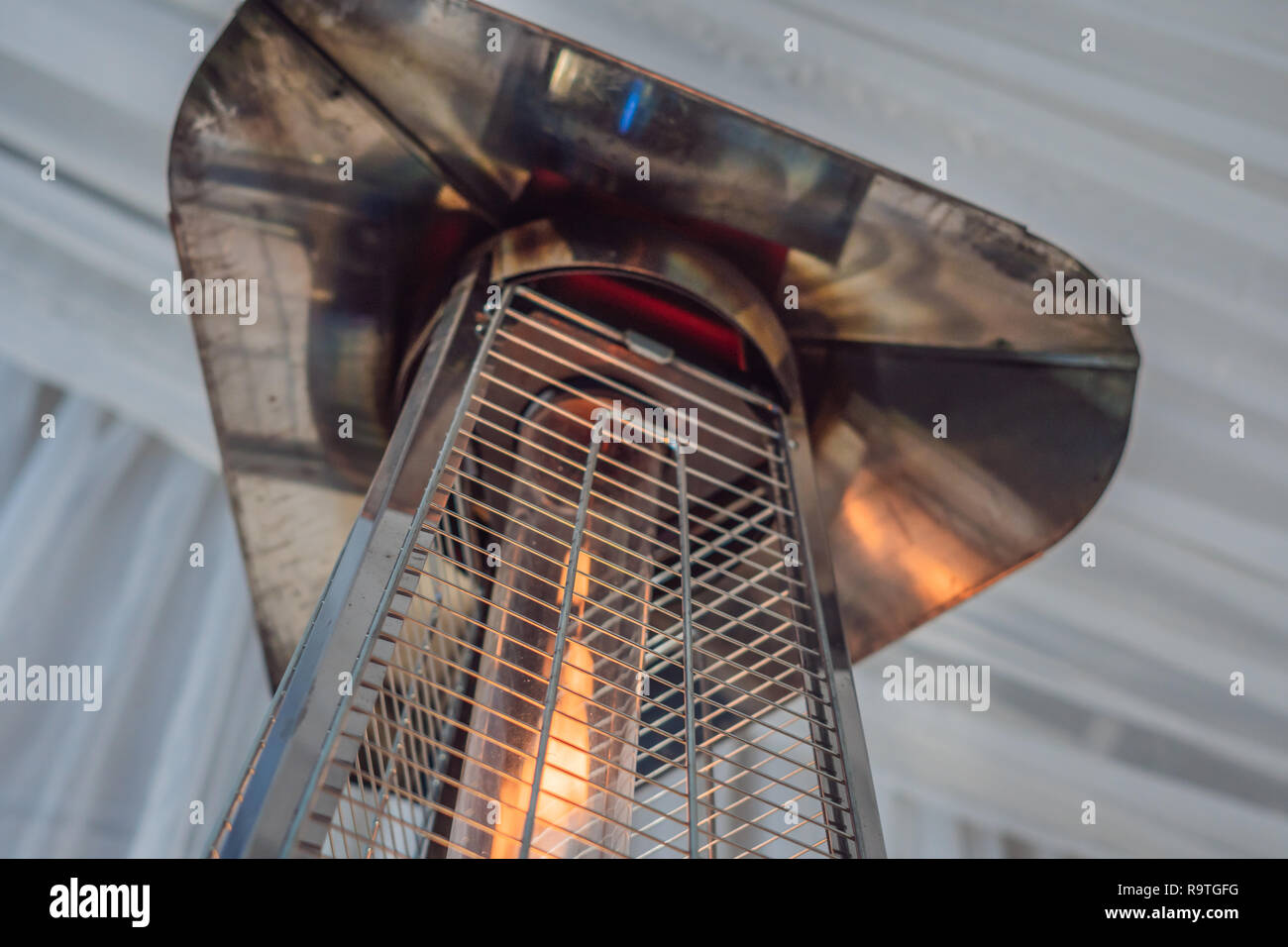 Heizlampe heizofen zwischen den Tischen eines offenen Cafe gesetzt. Stockfoto