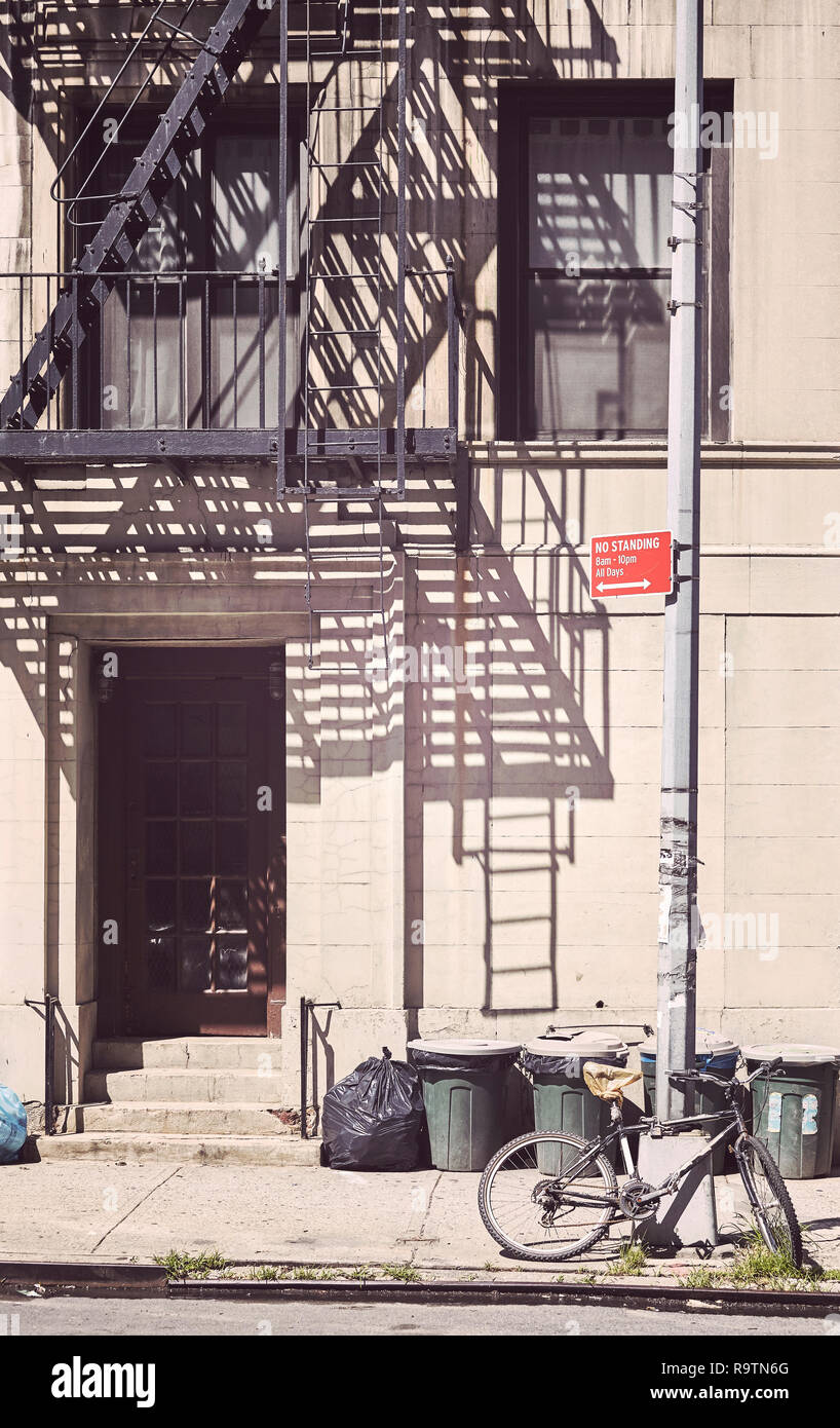 Mülltonnen und ein Fahrrad vor einem alten Haus in New York, Farbe Tonen angewendet, USA. Stockfoto
