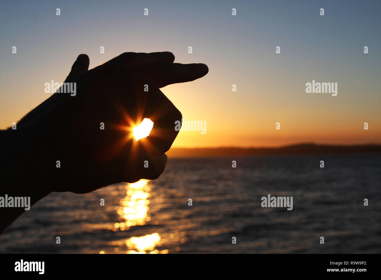 Sun stößt durch das Loch in meiner Hand Stockfoto