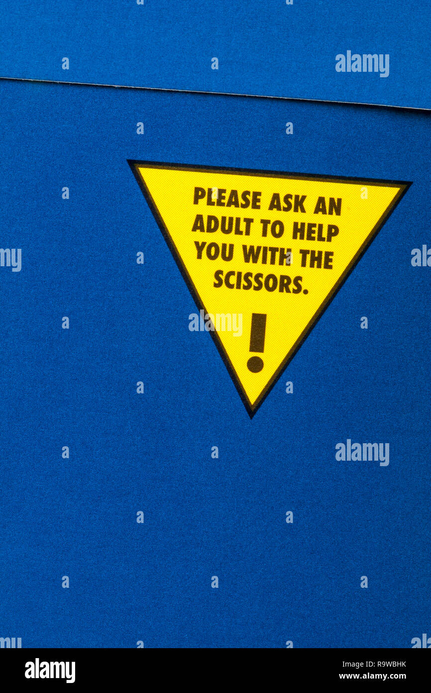 Bitte bitten Sie einen Erwachsenen, Ihnen mit der Schere zu helfen - Ratschläge für Kinder, um Rätsel auf der Rückseite des Adventskalenders auszuschneiden Stockfoto