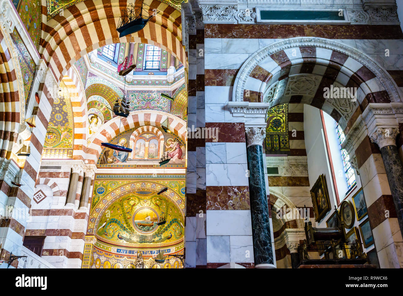 Die reich Mosaik eingerichtet Chor der Basilika Notre-Dame de la Garde in Marseille, Frankreich, mit Boot Modelle, die von der Decke hängen wie Ex-voto. Stockfoto