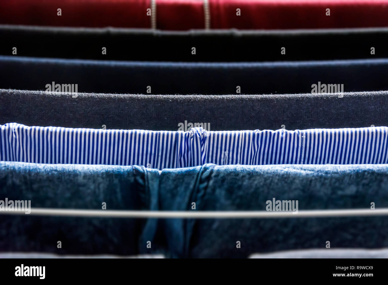 Verschiedene Arten von Kleidung links hängend auf einem Wäscheständer zum Trocknen Stockfoto