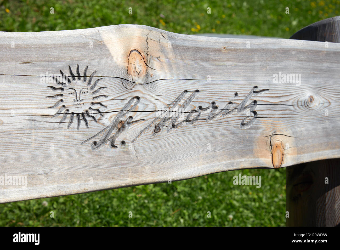 SANKT MORITZ, SCHWEIZ - 16. AUGUST 2018: Stadt logo mit Sonne in Holzbank plank an einem sonnigen Sommertag in Sankt Moritz, Schweiz geschnitzt Stockfoto