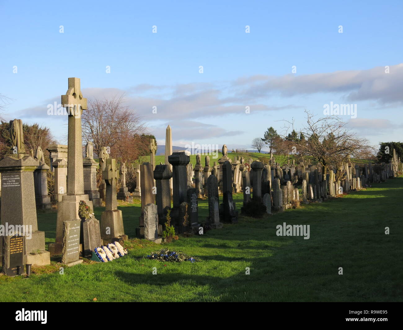 Blick auf die Grabsteine und Kreuze auf einem hellen Winter am Neuen Kilpatrick Friedhof, eine schöne Einstellung auf Boclair Hill, Bearsden, gasgow. Stockfoto