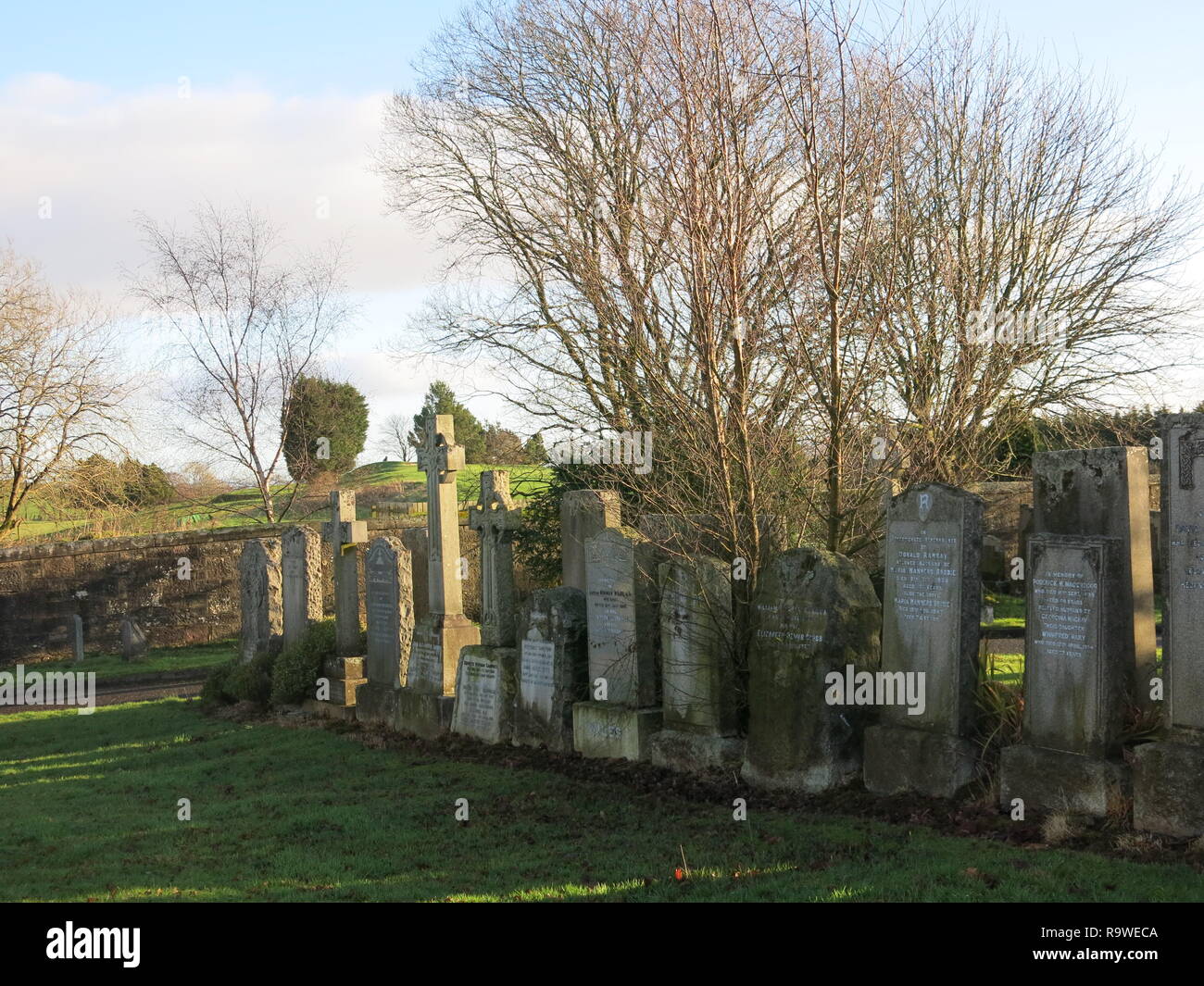 Blick auf die Grabsteine und Kreuze auf einem hellen Winter am Neuen Kilpatrick Friedhof, eine schöne Einstellung auf Boclair Hill, Bearsden, gasgow. Stockfoto