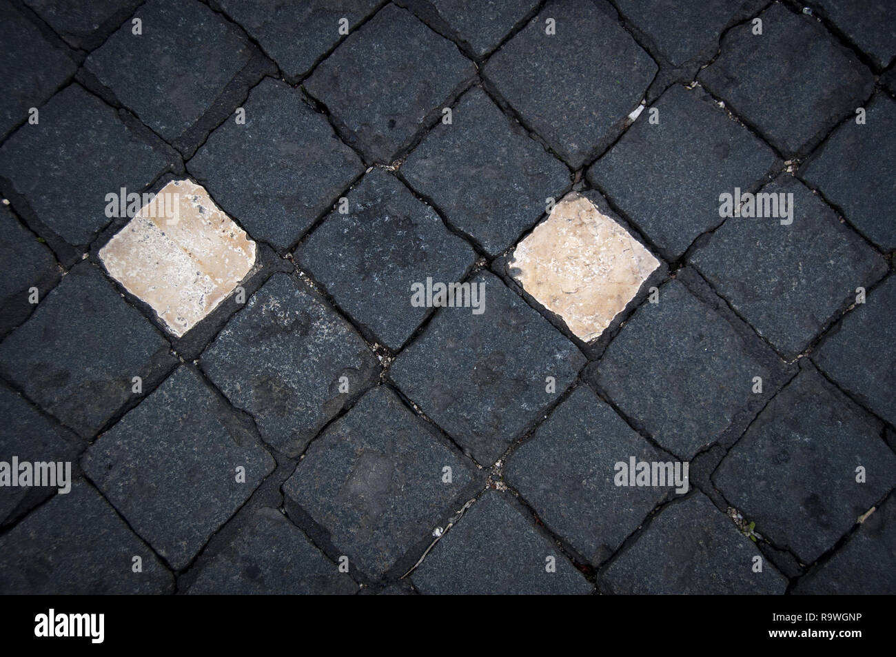 Spielen mit verschiedenen Formen und Muster einer gepflasterten Straßen von Lissabon (Portugal). Zwei weiße Kopfsteinpflaster umgeben von Schwarzen. Stockfoto