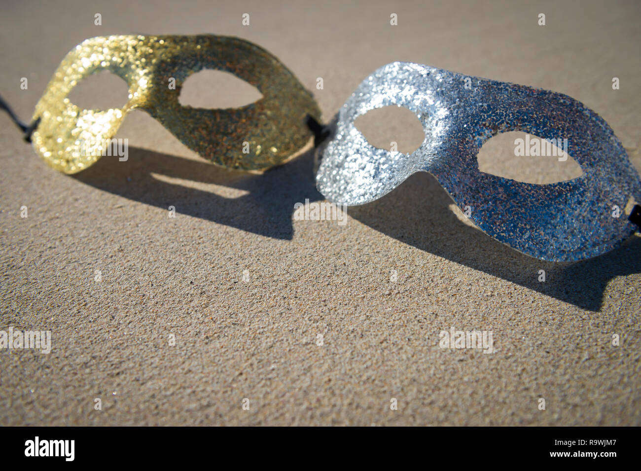 Funkelnde Gold und Silber Karneval Masken auf glatten Sand Strand in Rio de Janeiro, Brasilien ruhen Stockfoto