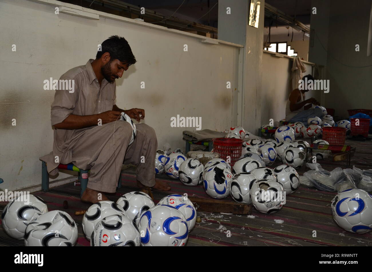 Pakistanische leder Industrie Arbeitnehmer workingin Football Factory. Stockfoto