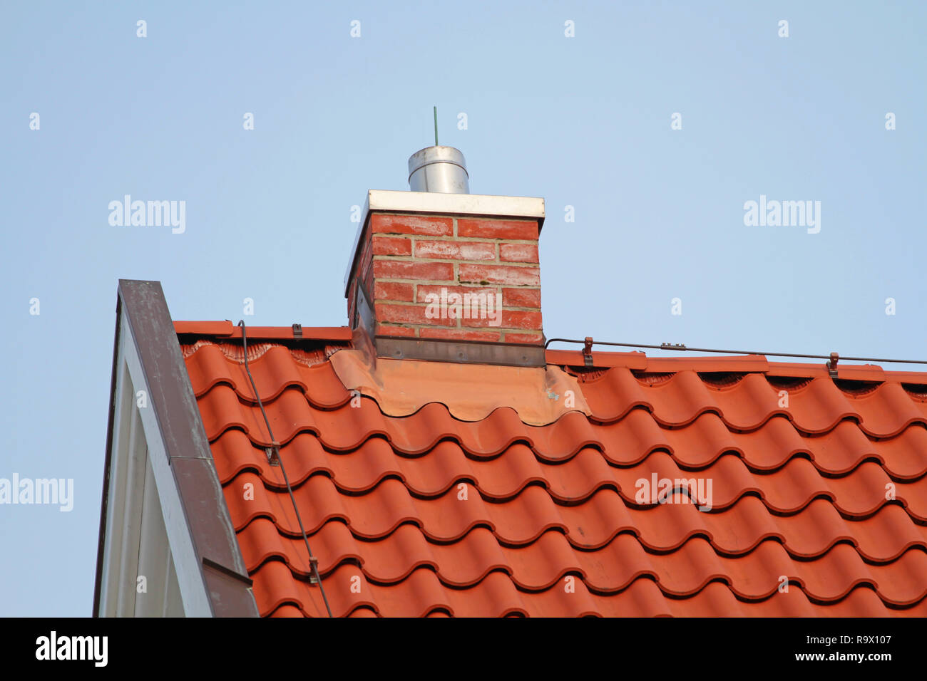 Gemauerten Schornstein auf dem roten Dach Stockfoto