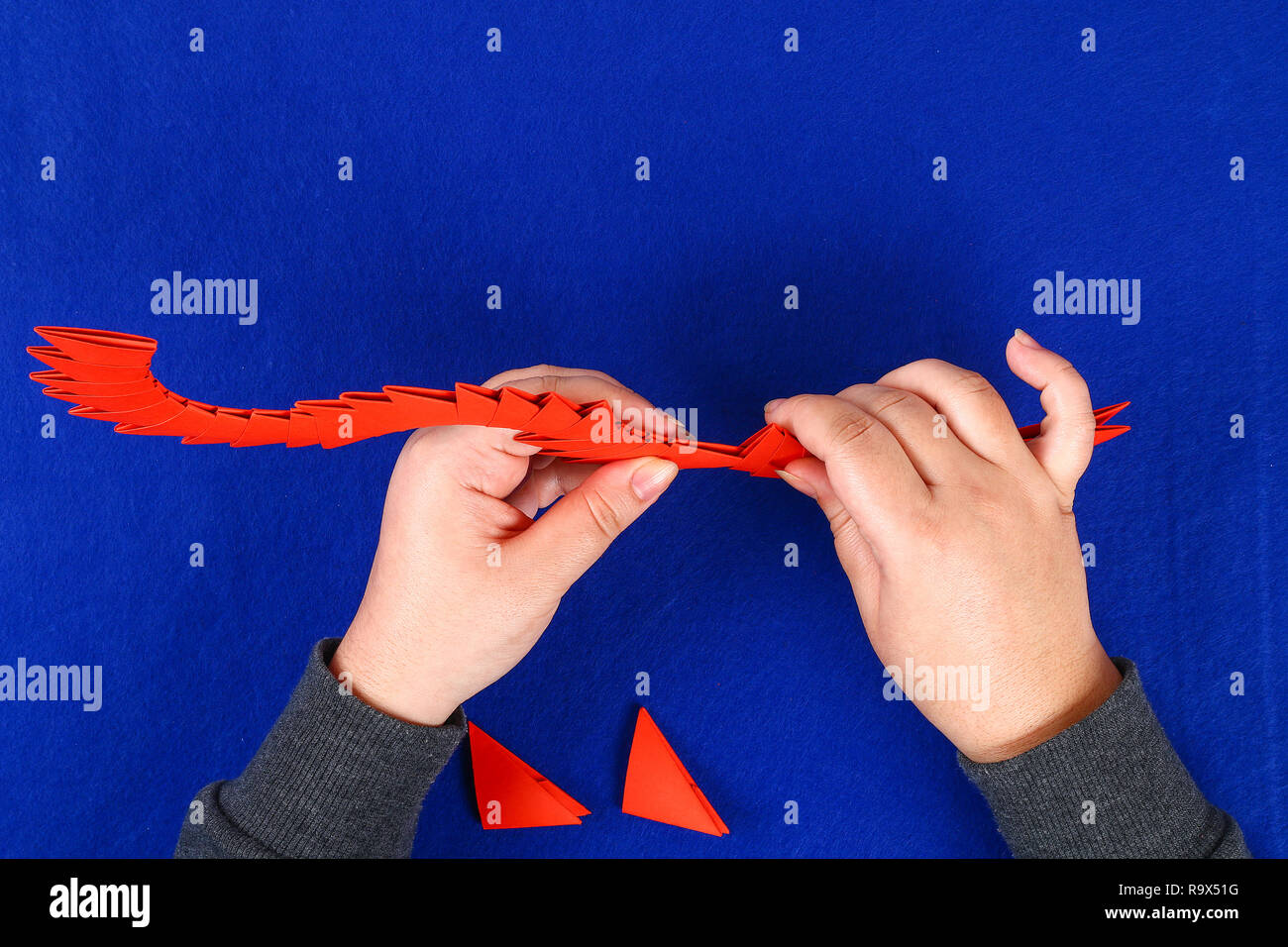 Diy chinesischer Drache auf blauem Hintergrund. Geschenkideen, die Einrichtung zum chinesischen Neujahrsfest. Handgefertigte rot gold Lunar dragon Lion von modular Origami. Schritt für Schritt. Die Stockfoto
