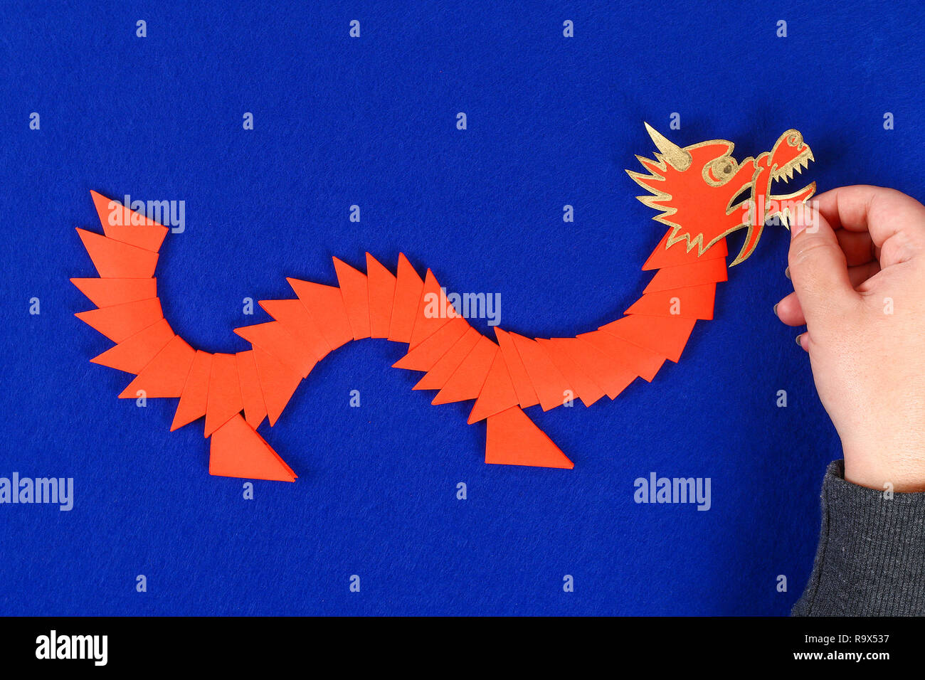 Diy chinesischer Drache auf blauem Hintergrund. Geschenkideen, die Einrichtung zum chinesischen Neujahrsfest. Handgefertigte rot gold Lunar dragon Lion von modular Origami. Schritt für Schritt. Die Stockfoto