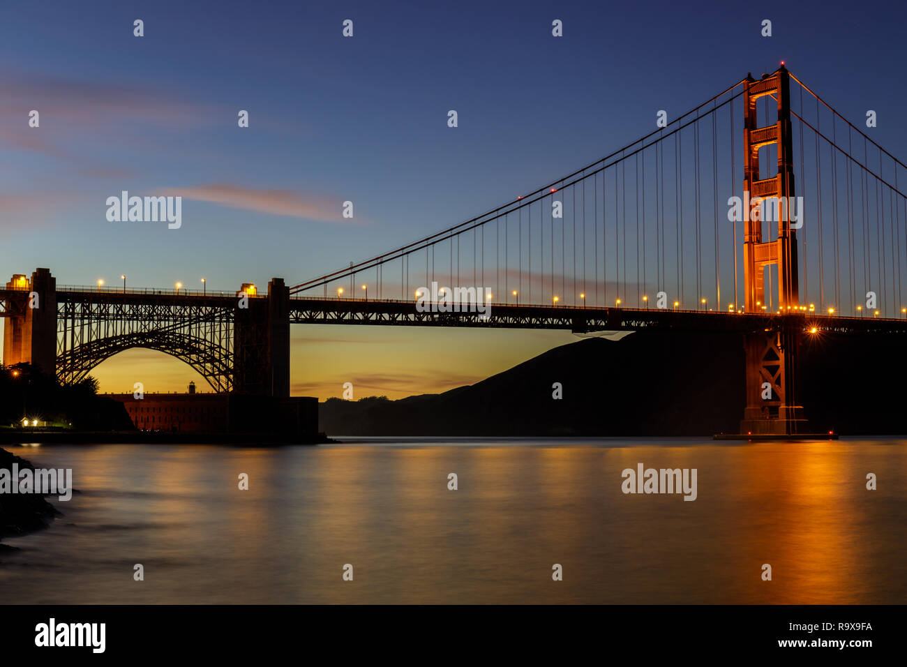 Twilight Lichter über die Golden Gate Bridge in der Nähe von Fort Point gesehen. Stockfoto