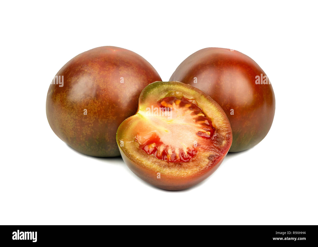 Zwei kumato Tomaten mit einem saftigen Hälfte auf weißem Hintergrund Stockfoto