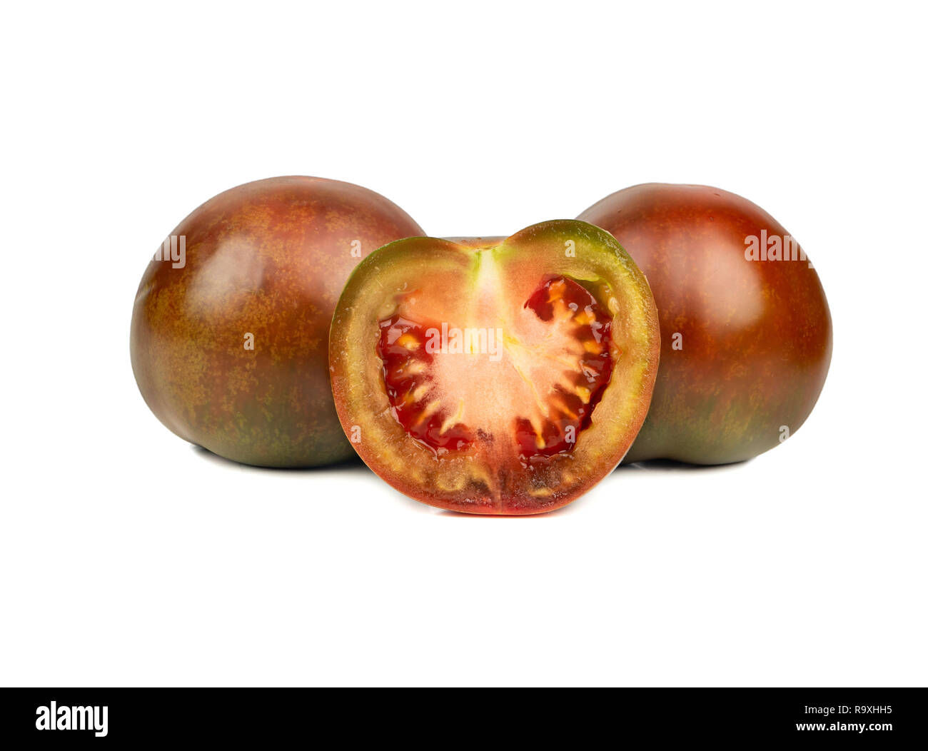 Zwei kumato Tomaten mit einem saftigen Hälfte auf weißem Hintergrund Stockfoto