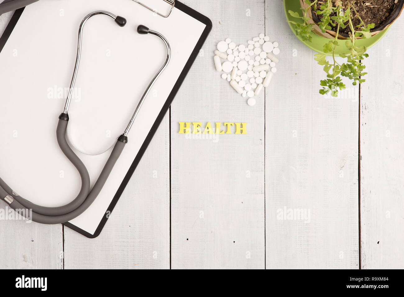 Medizinisches Konzept - Stethoskop, pad, Flasche, Weiß Herz von Pillen und Kapseln, Gesundheit Beschriftung auf weißem Schreibtisch aus Holz Stockfoto