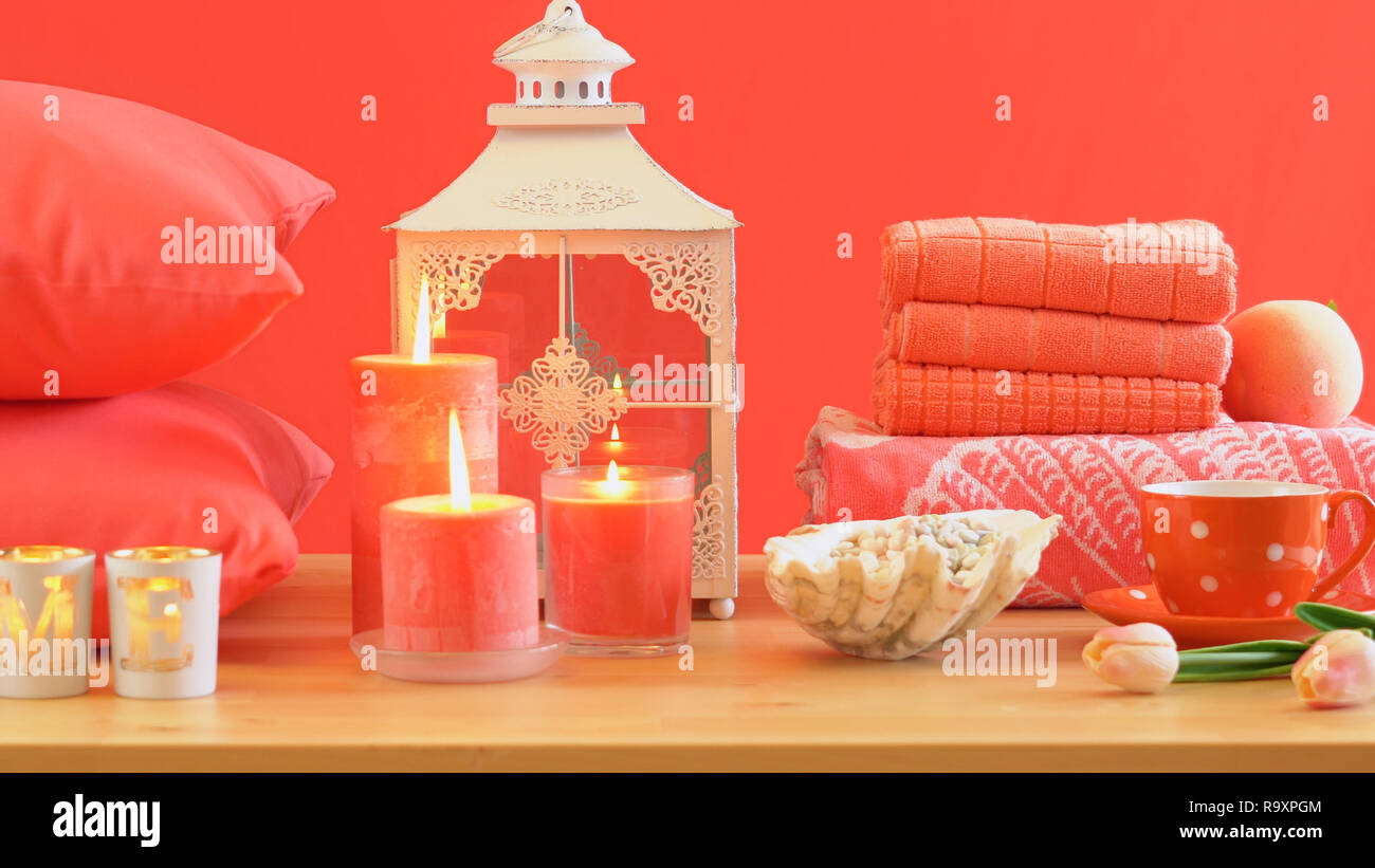 Lebende Koralle2019 Farbe des Jahres homewares Tisch mit Kerzen, Bettwäsche und Kissen Einrichtung werfen. Stockfoto