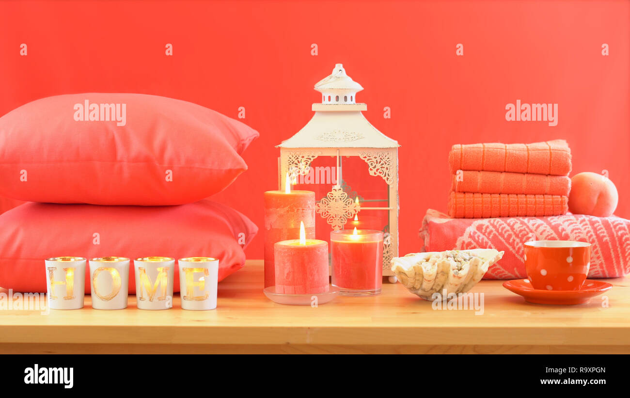 Lebende Koralle2019 Farbe des Jahres homewares Tisch mit Kerzen, Bettwäsche und Kissen Einrichtung werfen. Stockfoto