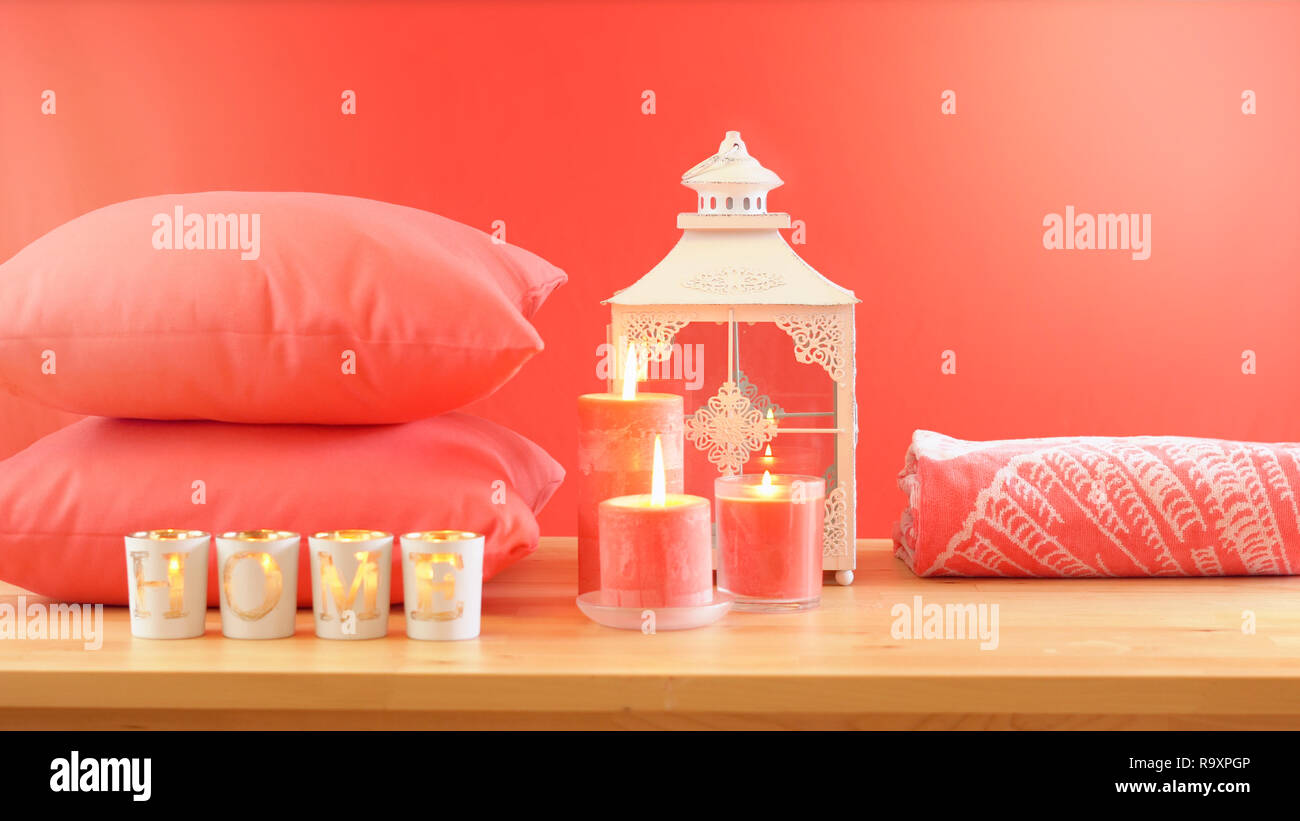 Lebende Koralle2019 Farbe des Jahres homewares Tisch mit Kerzen, Bettwäsche und Kissen Einrichtung werfen, mit Lens flare Stockfoto