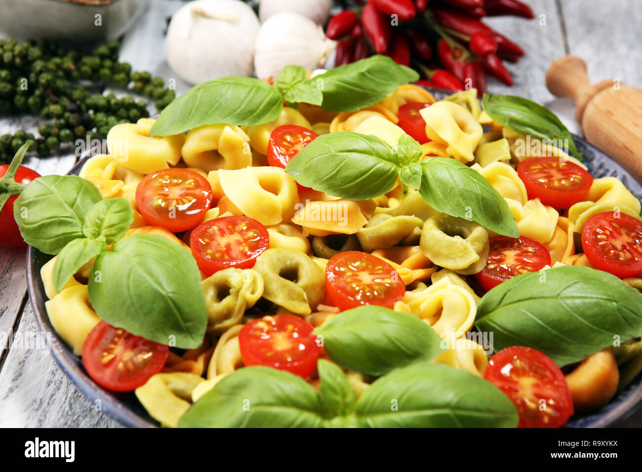 Pasta. tricolor Tortellini Pasta Salat mit Tomaten und Zwiebeln auf Holz Tisch Hintergrund Stockfoto