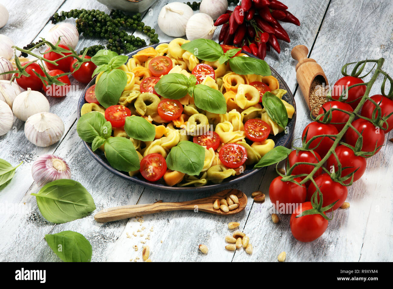 Pasta. tricolor Tortellini Pasta Salat mit Tomaten und Zwiebeln auf Holz Tisch Hintergrund Stockfoto