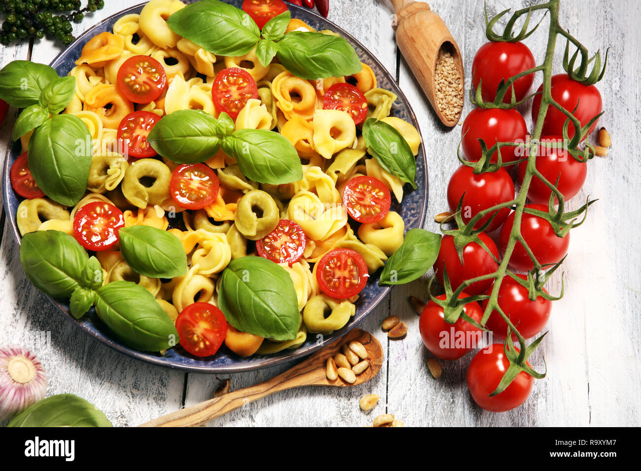 Pasta. tricolor Tortellini Pasta Salat mit Tomaten und Zwiebeln auf Holz Tisch Hintergrund Stockfoto