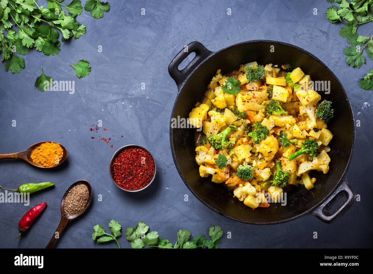 Indischen Aloo Gobi Gericht mit Kartoffeln, Blumenkohl und Gewürzen auf die texturierte grunge Hintergrund Stockfoto