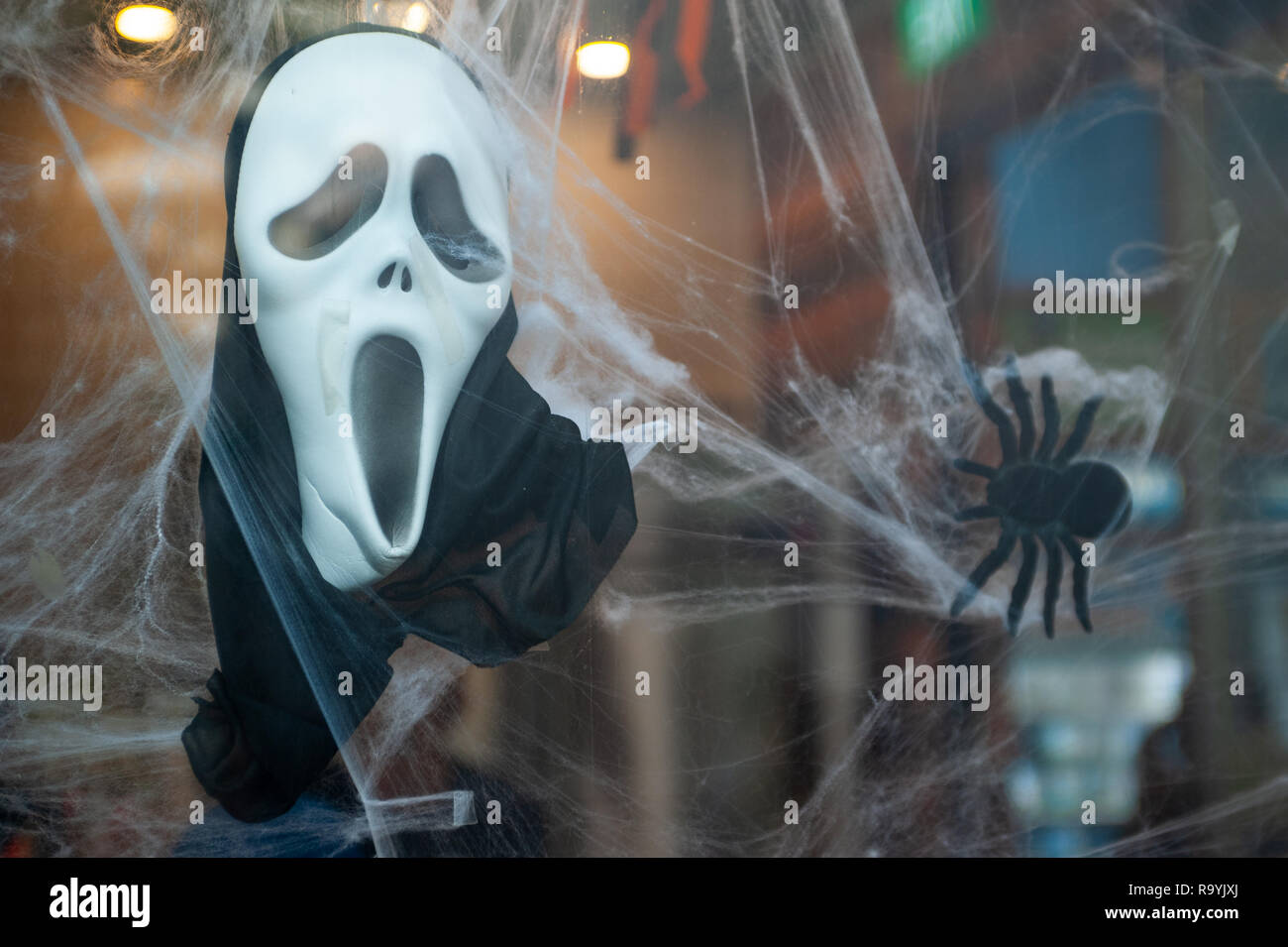 27.10.2018, Singapur, Republik Singapur, Asien - eine Scream-Maske und eine Spinnenattrappe Halloweendekoraton haengen als in 1963, 1999. 0 SL 1. Stockfoto