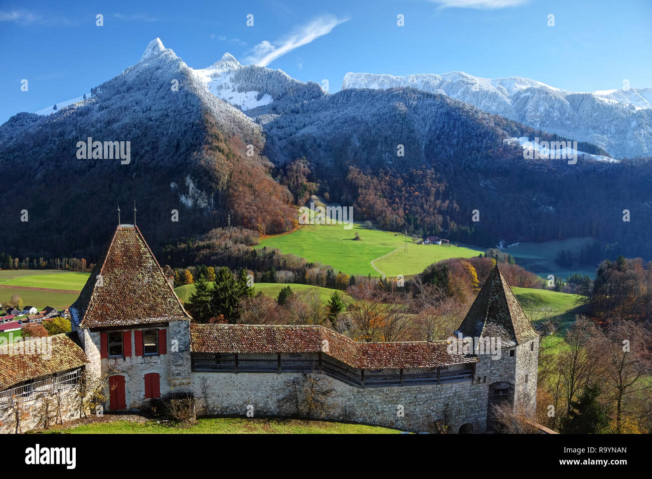 Festungsmauer und schneebedeckte Berge hinter dem Château de Gruyères, Fribourg, Schweiz Stockfoto