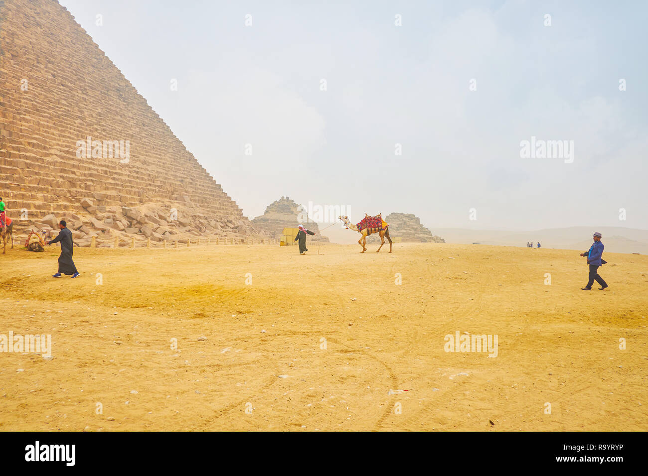 Gizeh, Ägypten - Dezember 20, 2017: Ägyptische bedouin Treibern in der traditionellen Kleidung bieten Tourist Transport Service auf Kamelen in der Pyramide, Deze Stockfoto