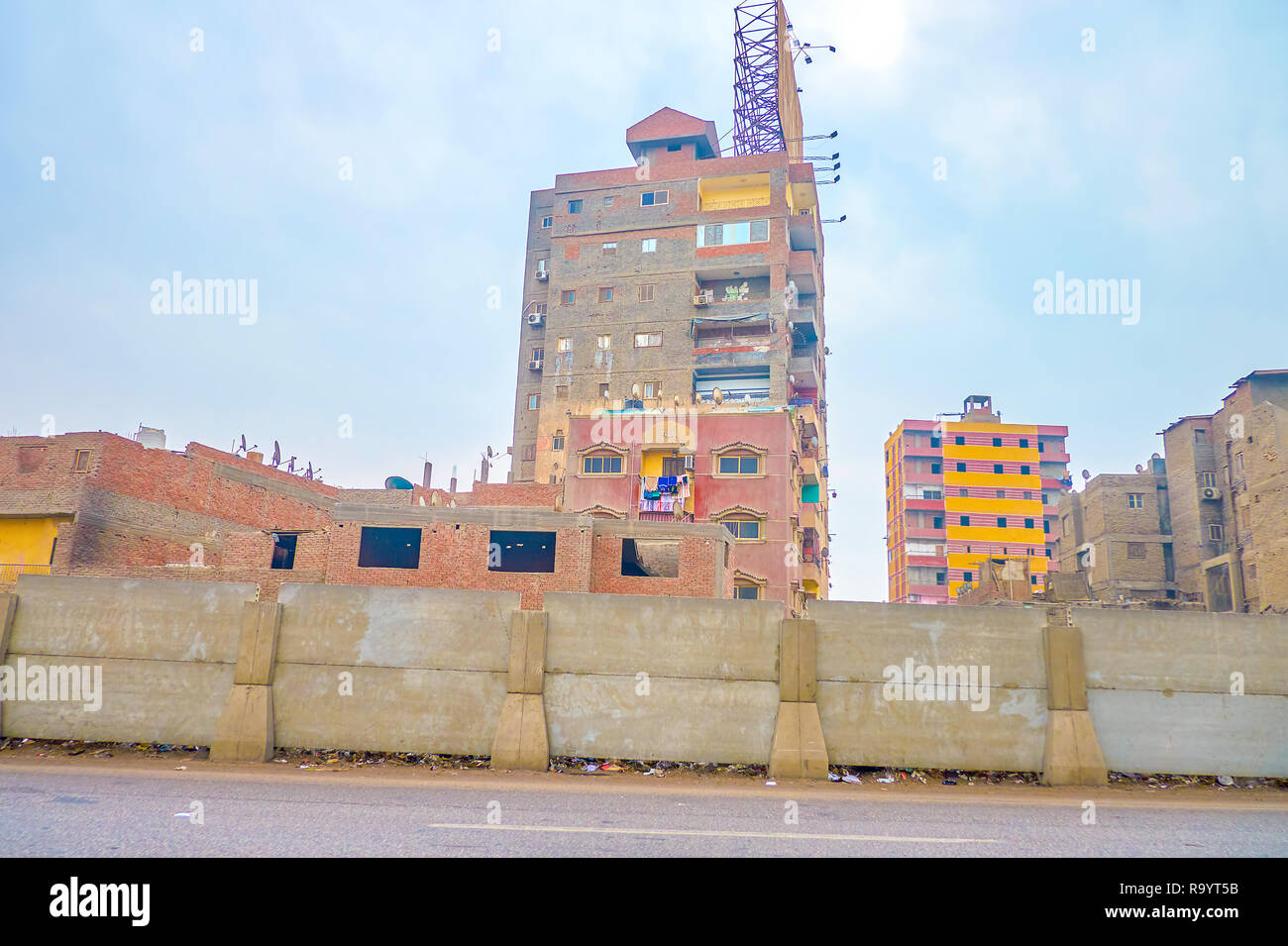 Das Wohnzimmer schäbig Hochhaus Nachbar mit unschönen unvollendete Gebäude in einem der Armenviertel von Kairo, Ägypten Stockfoto